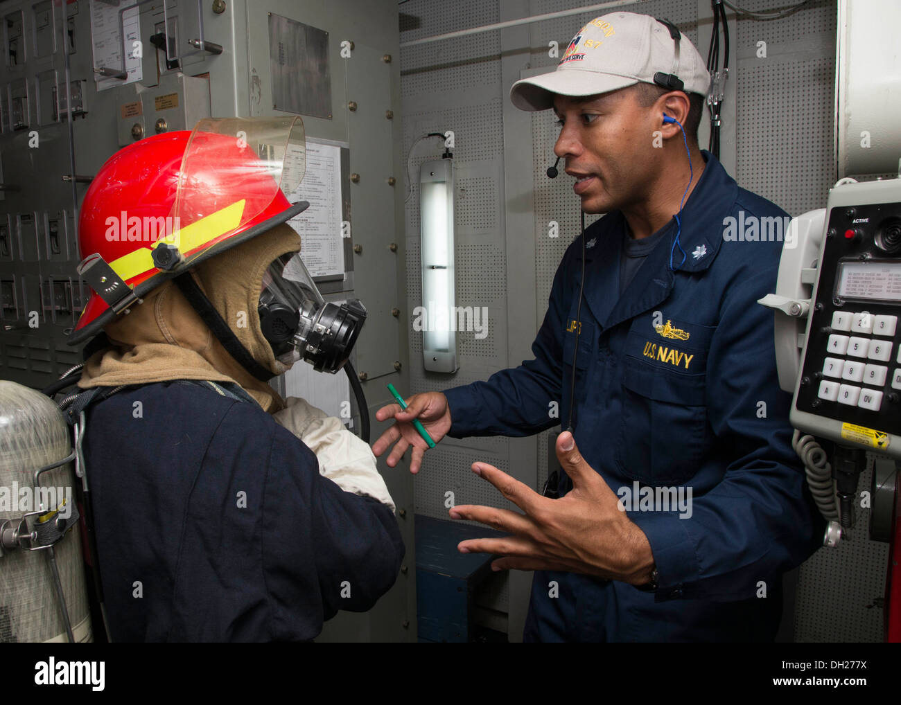 U.S. 5ÈME ZONE DE RESPONSABILITÉ DE LA FLOTTE (oct. 24, 2013) Le Cmdr. Mikal Phillips, directeur général de missiles de l'USS Mason (DDG 87), Technicien en électronique, indique à droite 2e classe Tiffany Conner au bon contrôle des dommages pendant une Banque D'Images