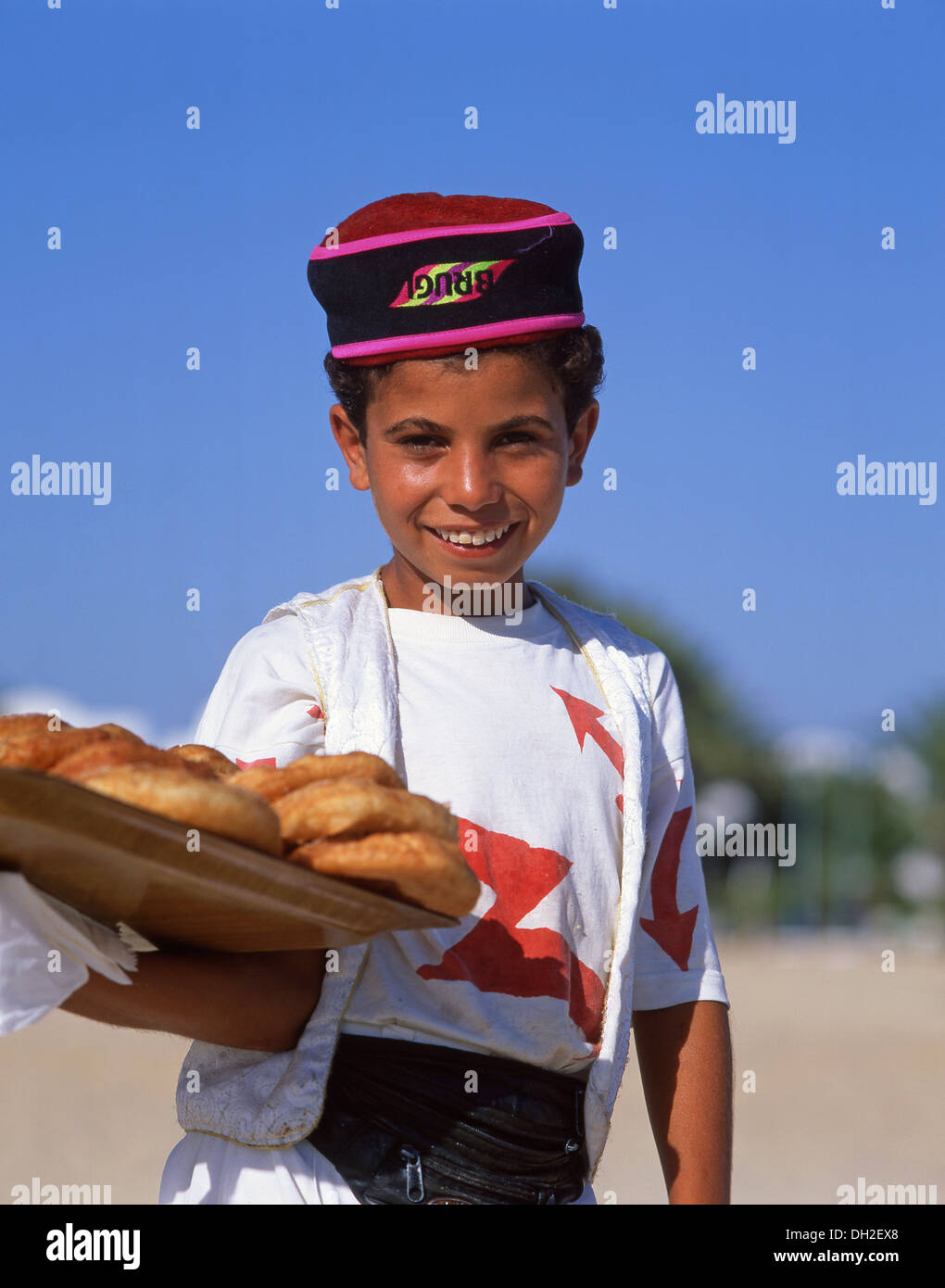 Jeune garçon vente de pâtisseries sur la plage de Sousse, Sousse, Sousse, Tunisie Gouvernorat Banque D'Images