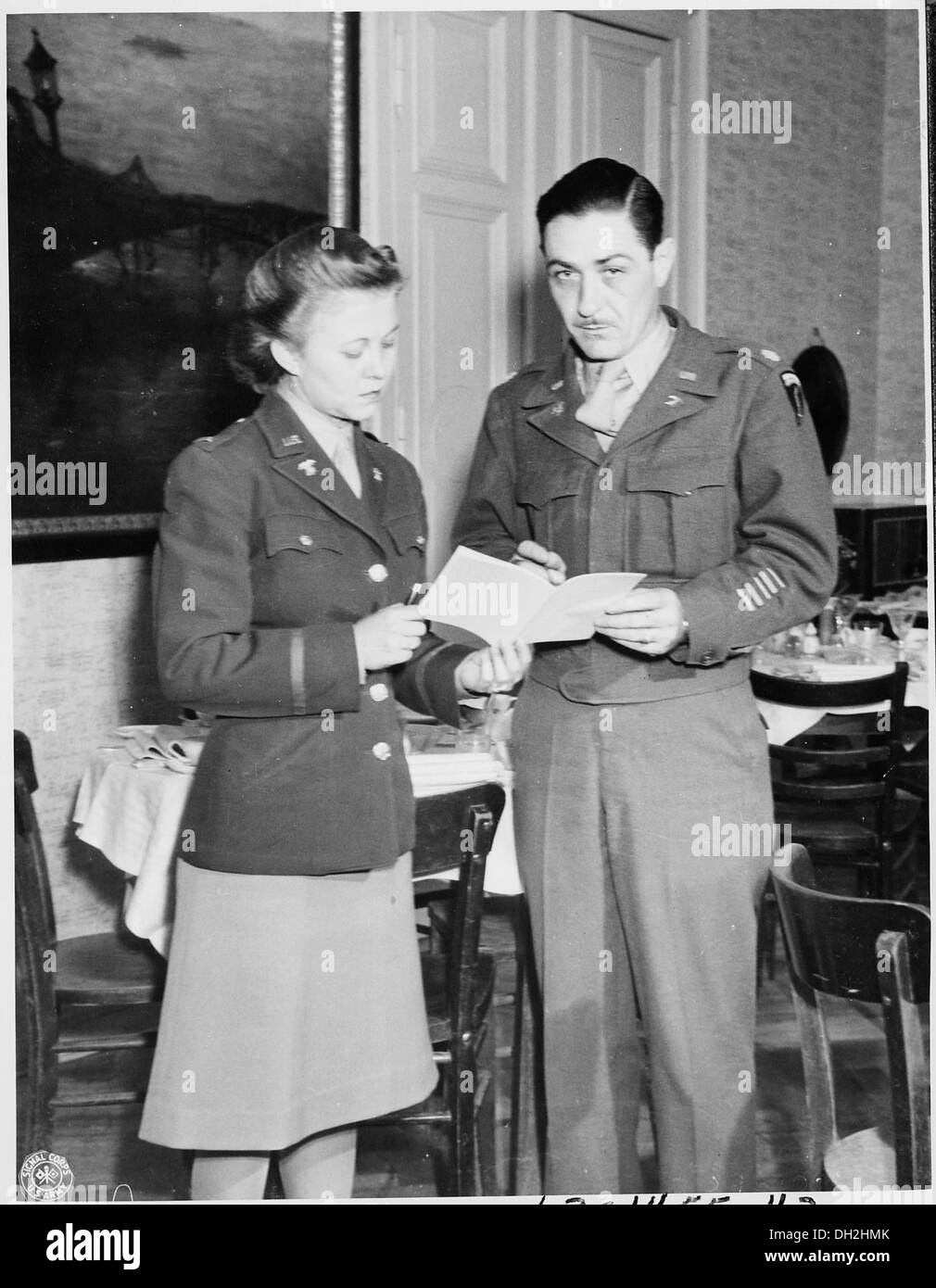 Le major John E. Lennox, chef de tous les mess américains, discute du menu quotidien avec le lieutenant May K. Felts, diététicien, soulignant l'importance de la planification des repas dans la vie militaire. Banque D'Images