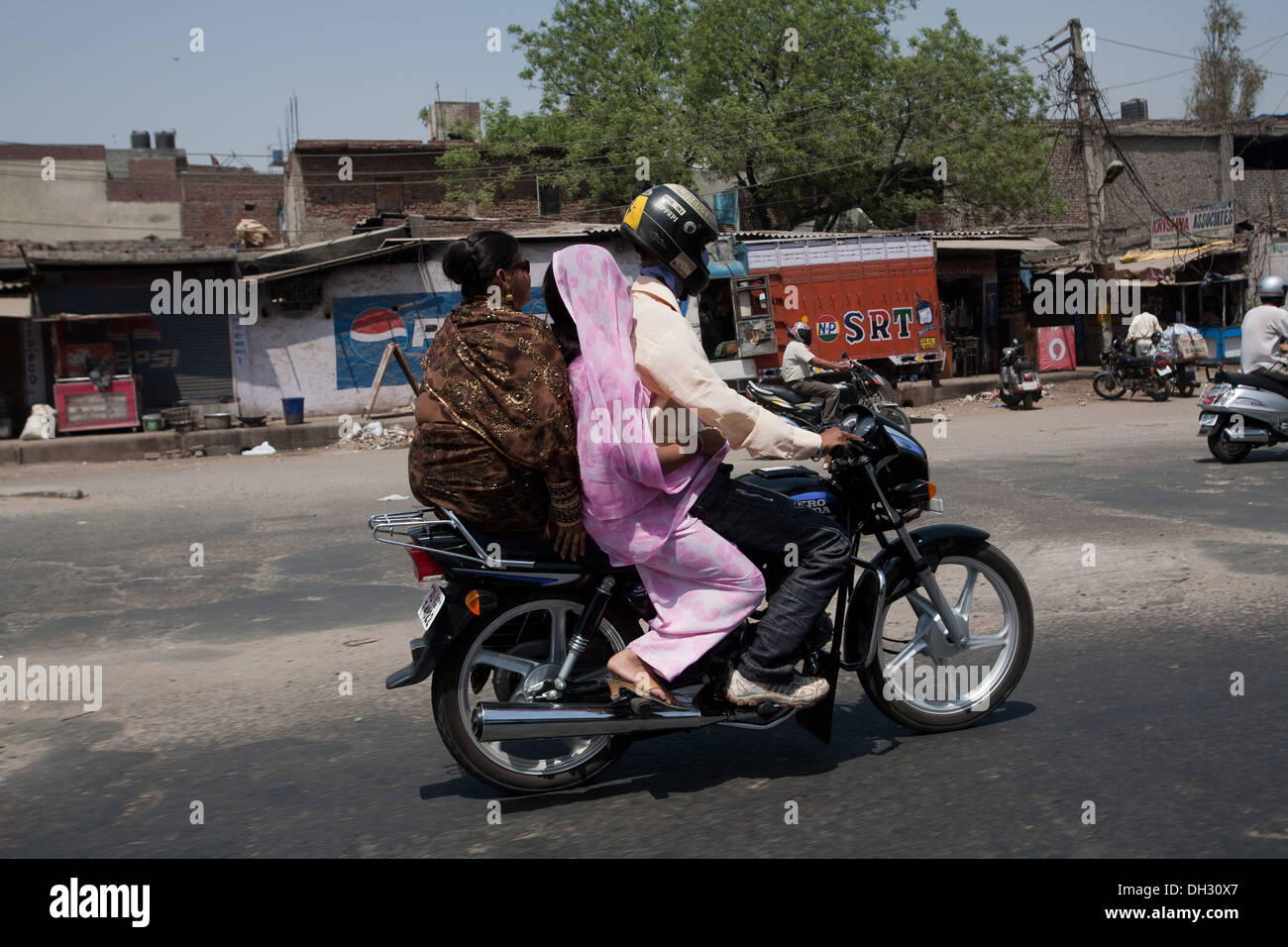 Famille en moto dans les rues près de New Delhi Inde Asie Banque D'Images