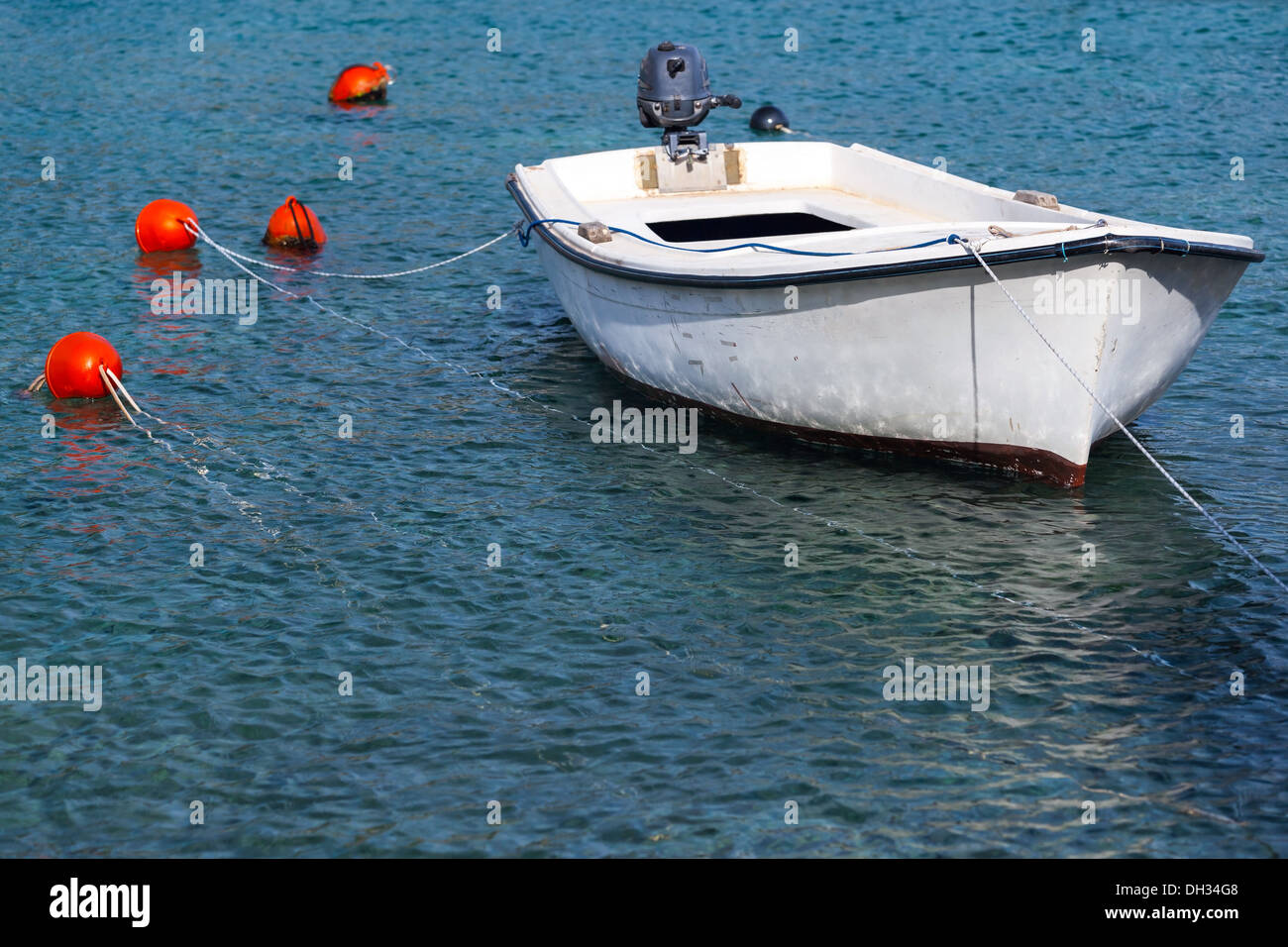 Bateau de pêche en bois blanc flotte amarré dans l'eau de mer Adriatique, le Monténégro Banque D'Images