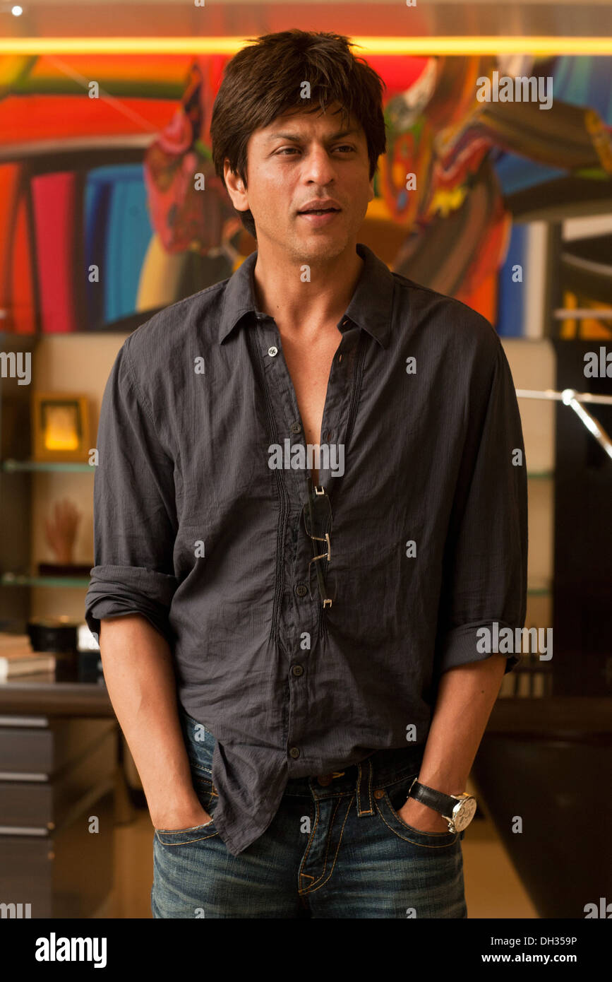 Acteur de film hindi bollywood indien Shah Rukh Khan portant chemise noire debout avec les mains dans ses poches de jeans bleu Asie Inde Banque D'Images