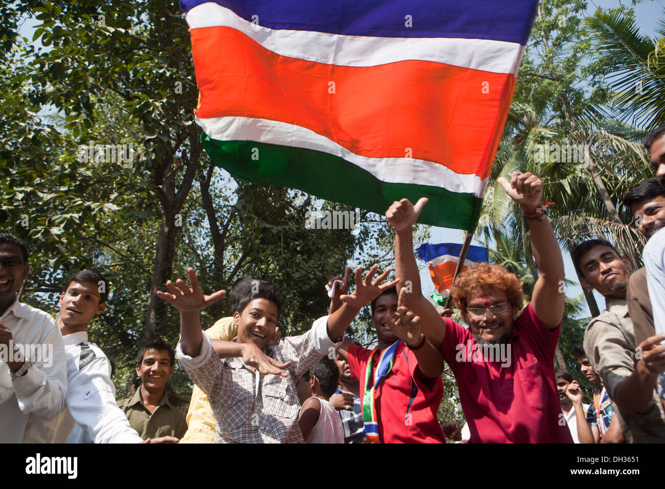 Les hommes de la danse en agitant le drapeau des partisans de la MNS célébrant la victoire électorale du candidat Parti politique MNS Mumbai Maharashtra Inde Asie Oct 2009 Banque D'Images