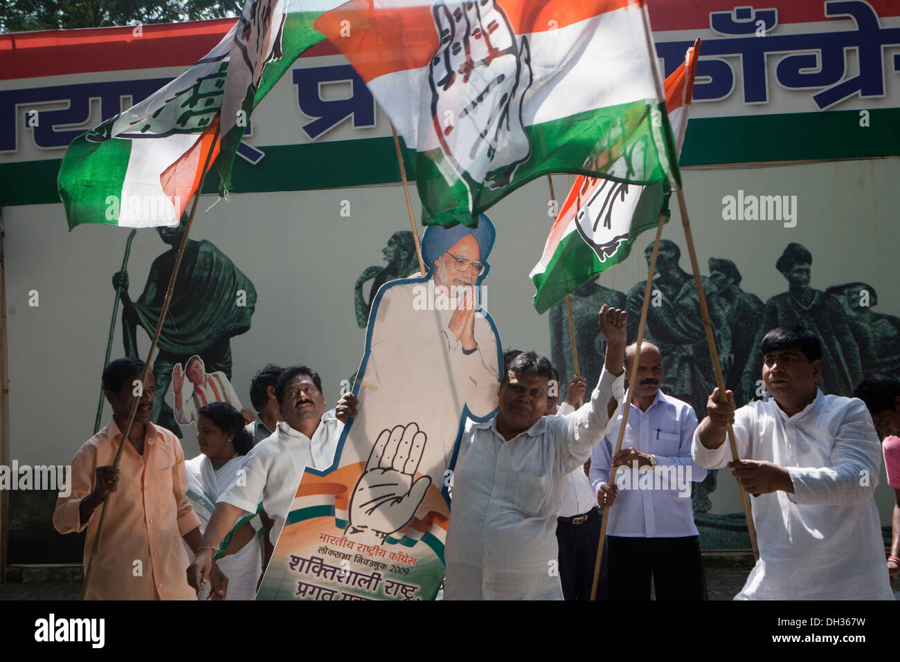Des partisans du parti politique Congrès célébrant la victoire en agitant des drapeaux du Congrès de l'affiche avec le Premier Ministre de l'Inde, Dr Manmohan Singh Mumbai Maharashtra Inde Asie Banque D'Images
