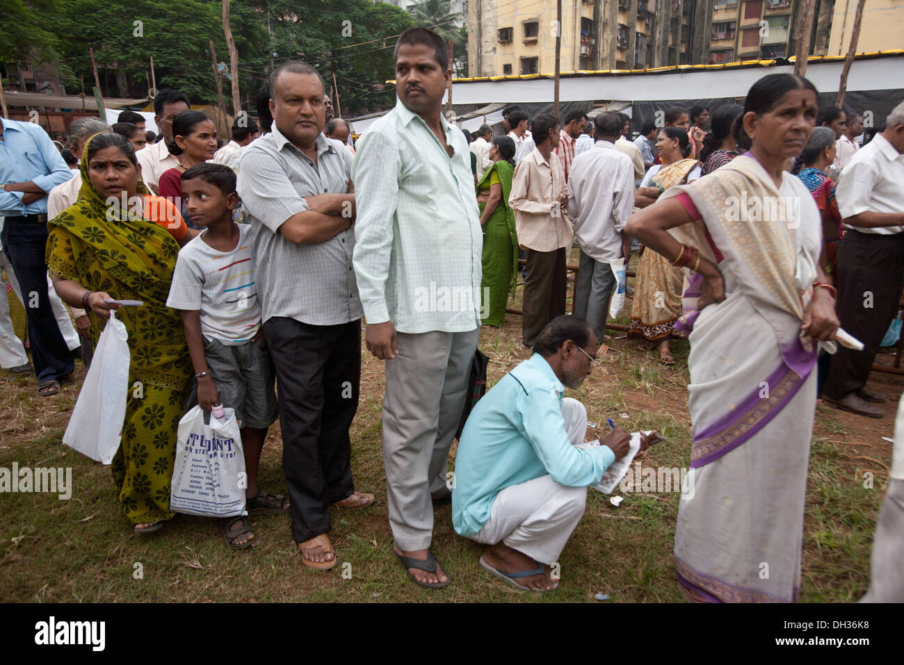 Les électeurs Hommes Femmes Enfants en file pour voter au bureau de scrutin électoral Mumbai Maharashtra Inde Asie Banque D'Images