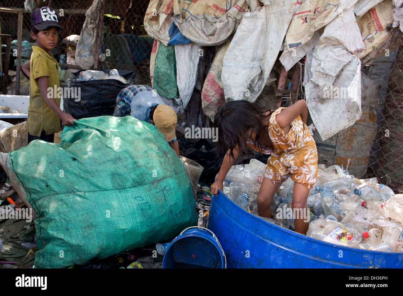 Une jeune fille se tient dans une baignoire en plastique d'écrasement de  bouteilles d'eau à un centre de recyclage à Phnom Penh, Cambodge Photo  Stock - Alamy