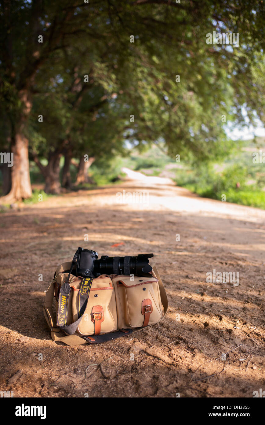 L'équipement et l'appareil photo Nikon sac sur un chemin de terre dans la campagne indienne. L'Andhra Pradesh, Inde Banque D'Images