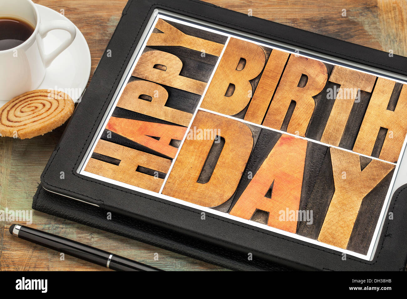 Joyeux anniversaire à la typographie numérique type de bois sur l'ordinateur tablette avec stylet, tasse de café et des cookies Banque D'Images