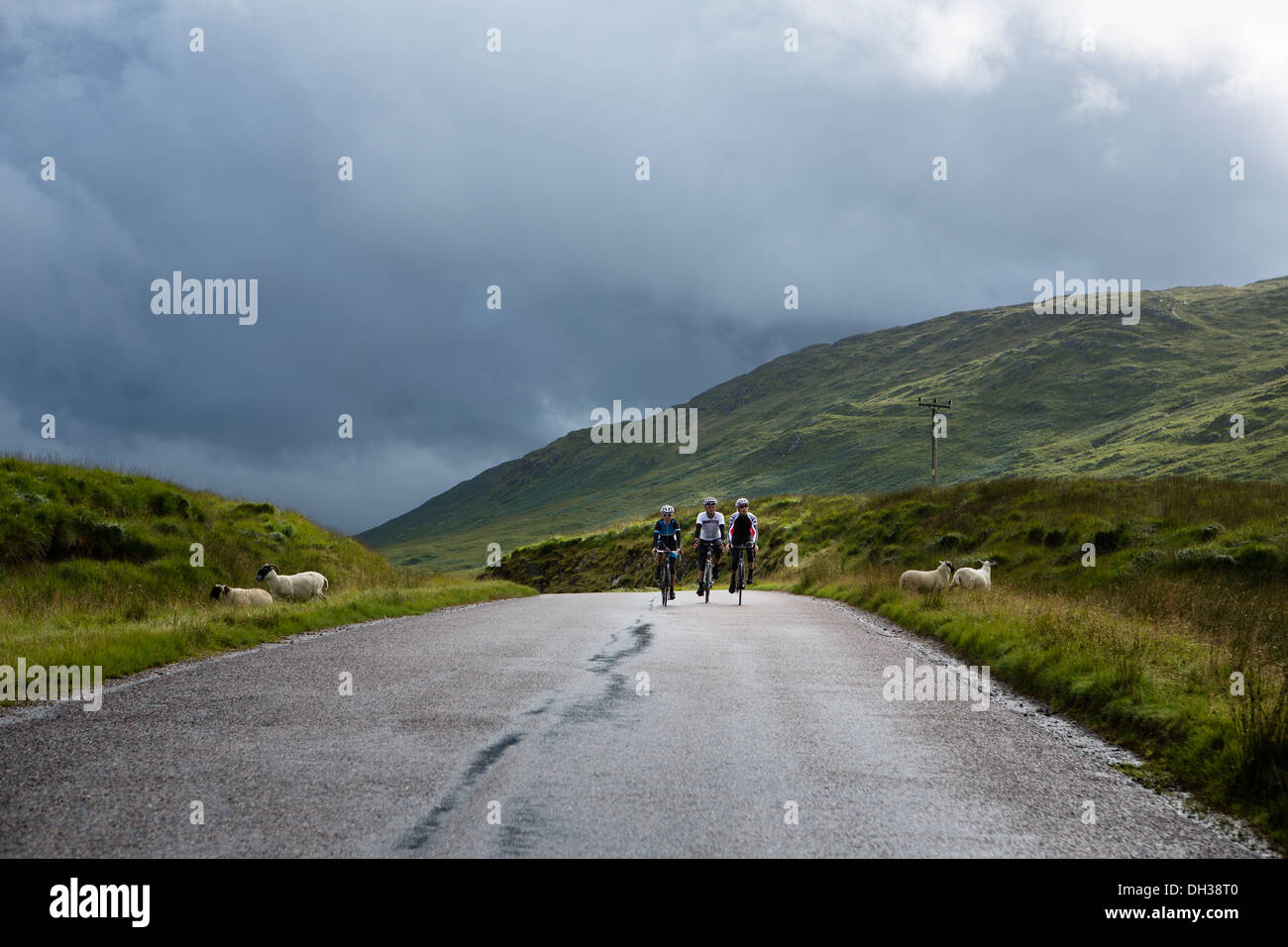 Trois cyclistes roulent un chemin humide dans les Highlands, Ecosse, Royaume-Uni Banque D'Images