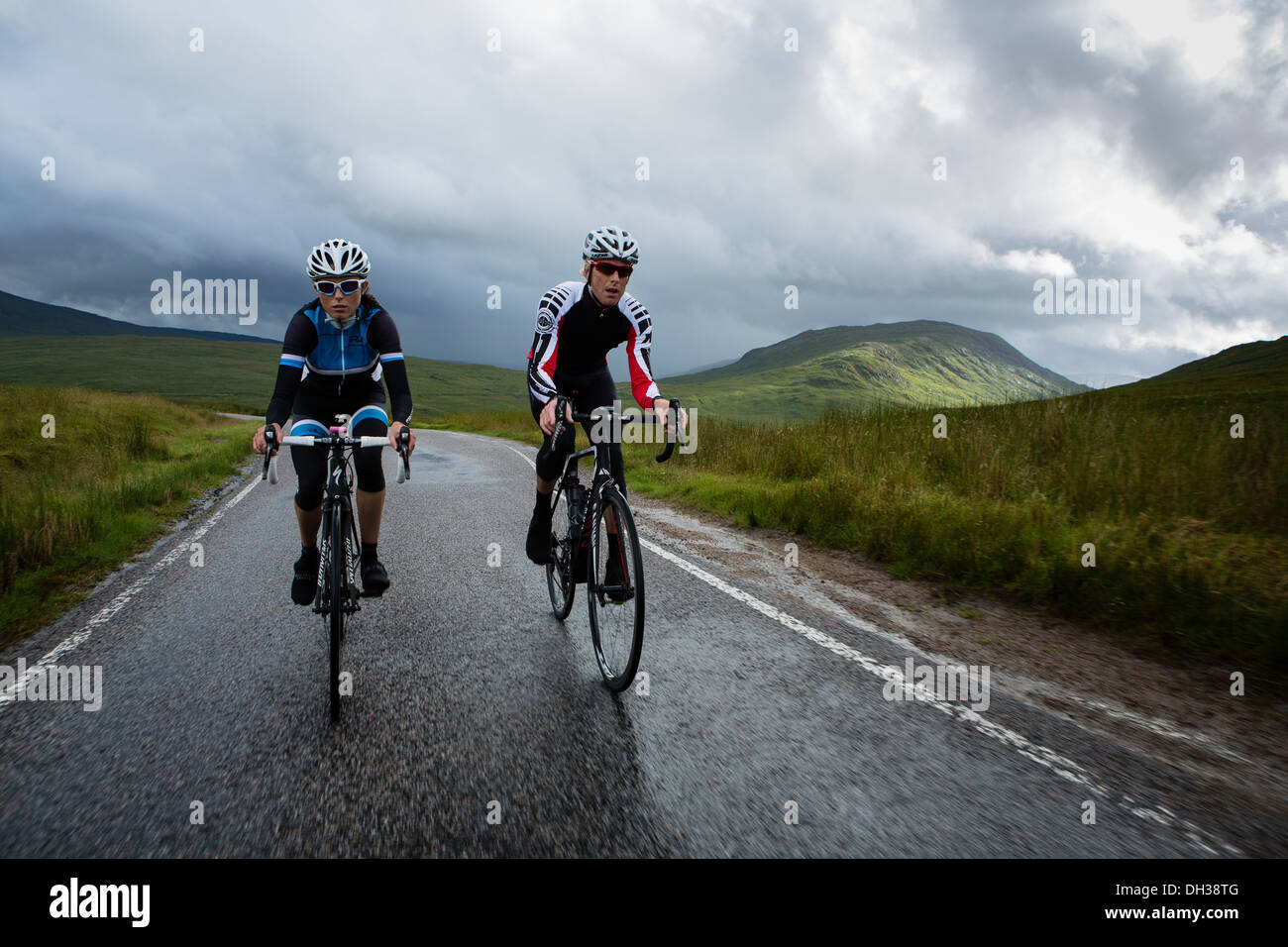 Paire de cyclistes roulent un chemin humide dans les Highlands, Ecosse, Royaume-Uni Banque D'Images