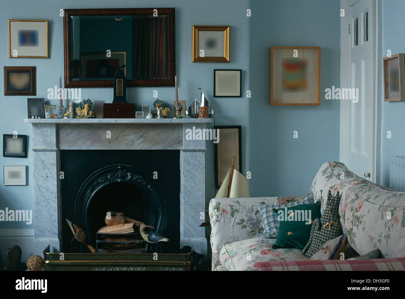 Miroir en acajou au-dessus de la cheminée de marbre en bleu pâle pays salon avec canapé floral Banque D'Images