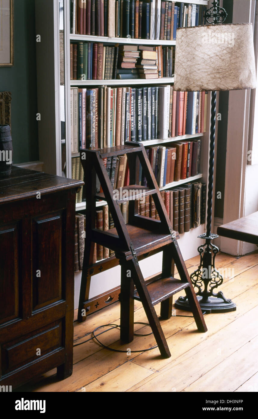 Bibliothèque en bois ancien et des mesures standard en fer forgé lampe avec abat-jour parchemin contre bibliothèque avec livres reliés en cuir Banque D'Images