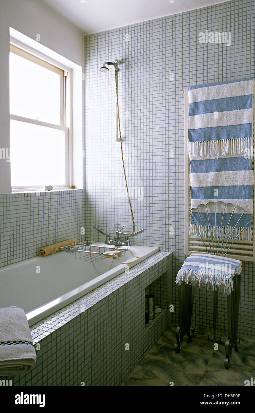 Blue +blanc à rayures serviette sur le radiateur mural en mosaïque moderne  salle de bains carrelée avec douche mural au-dessus de baignoire Photo  Stock - Alamy