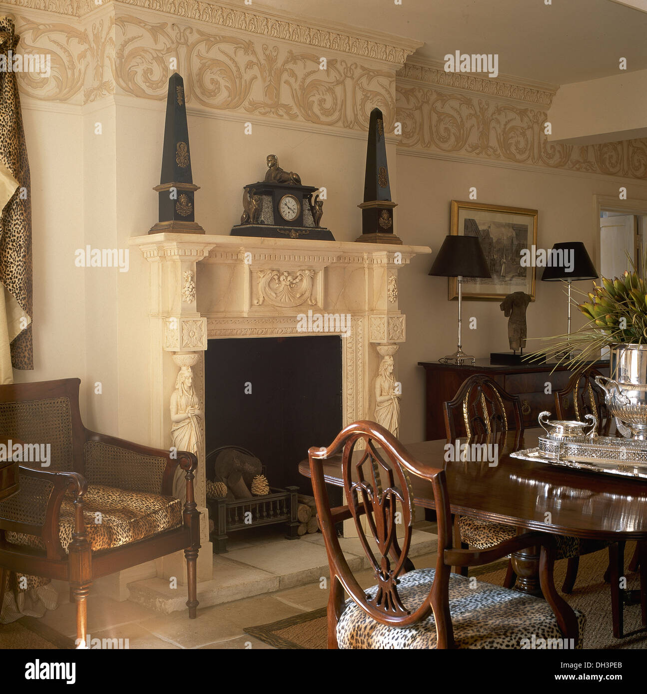Obélisques classiques de chaque côté de l'horloge ancienne cheminée ouvragée sur dans la salle à manger avec frise peinte à la main de plafond ci-dessous Banque D'Images