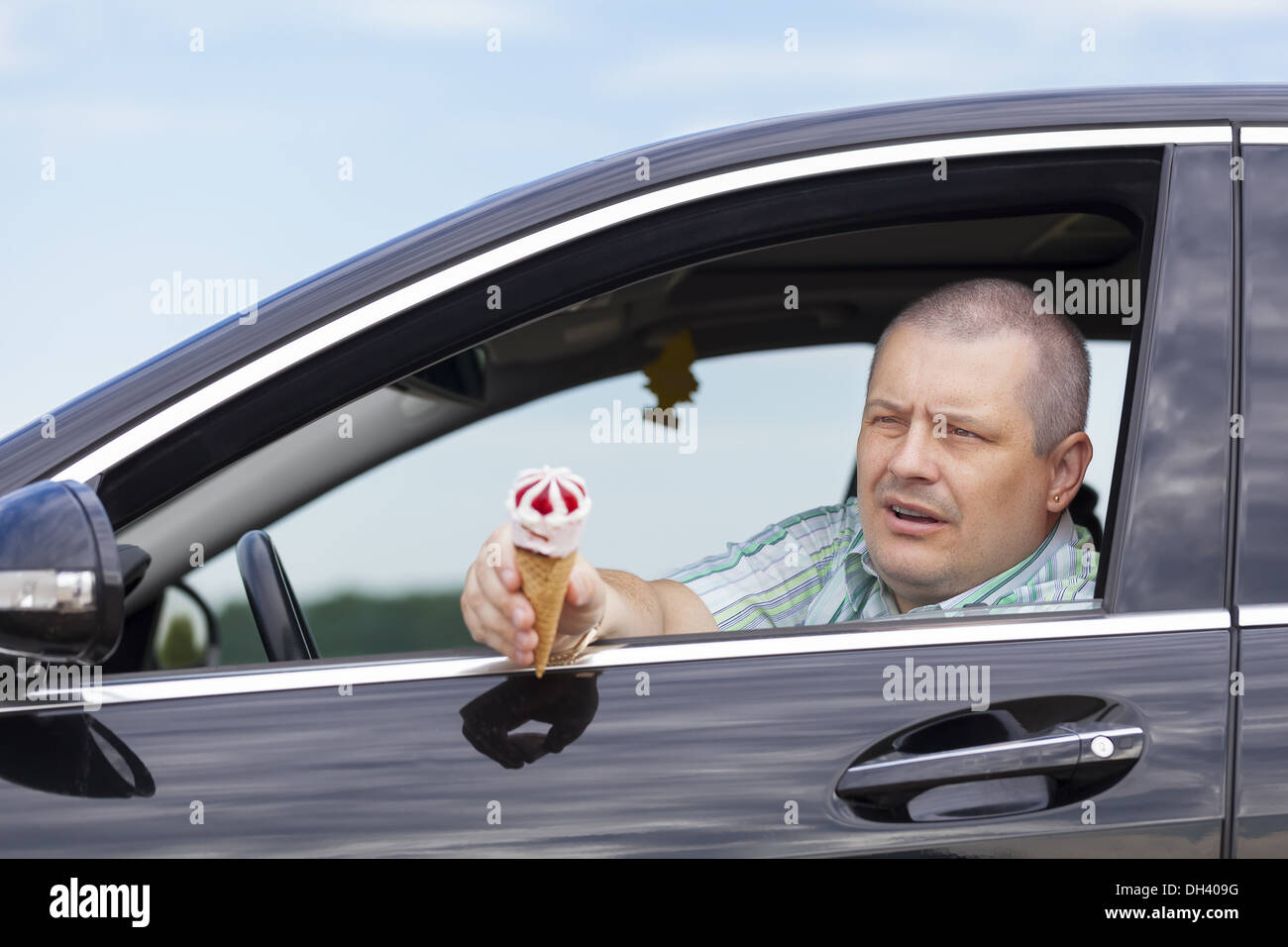 Homme assis dans une voiture prix de la crème glacée Banque D'Images