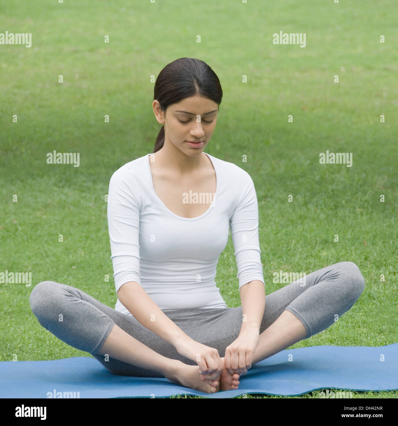 Woman practicing yoga in a park Banque D'Images