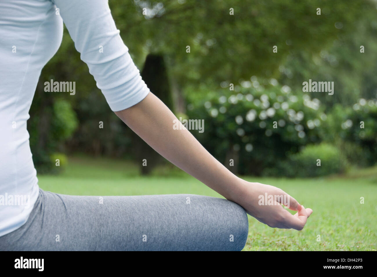 Woman practicing yoga in a park Banque D'Images