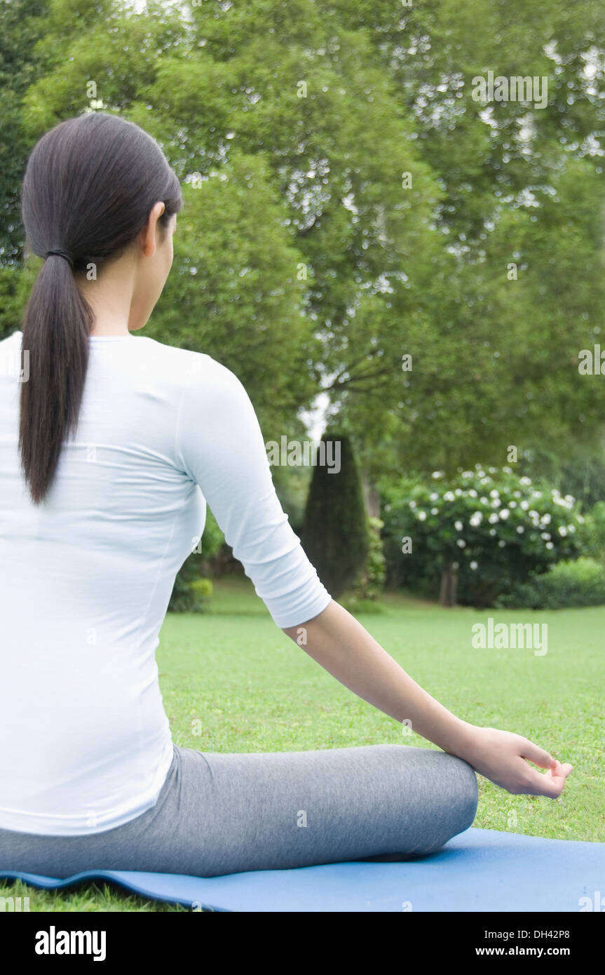 Woman practicing yoga in a park Banque D'Images