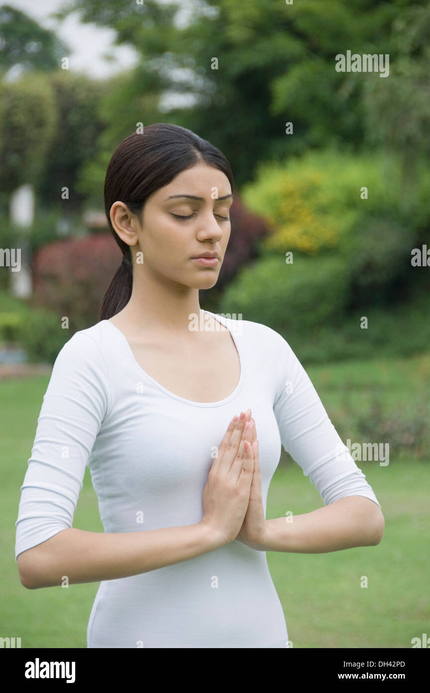 Woman practicing yoga in a park Banque D'Images