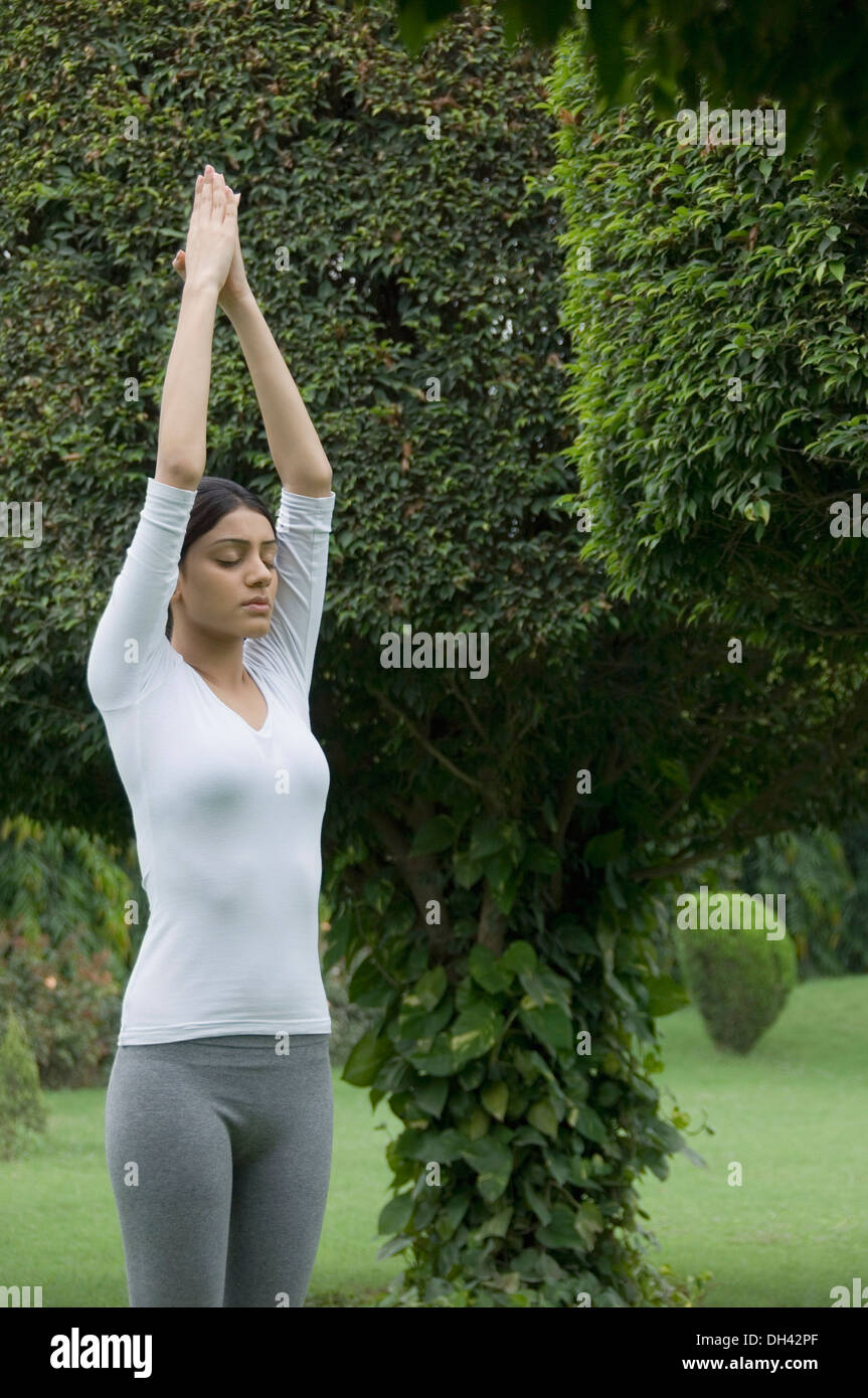 Woman practicing yoga in a park Banque D'Images