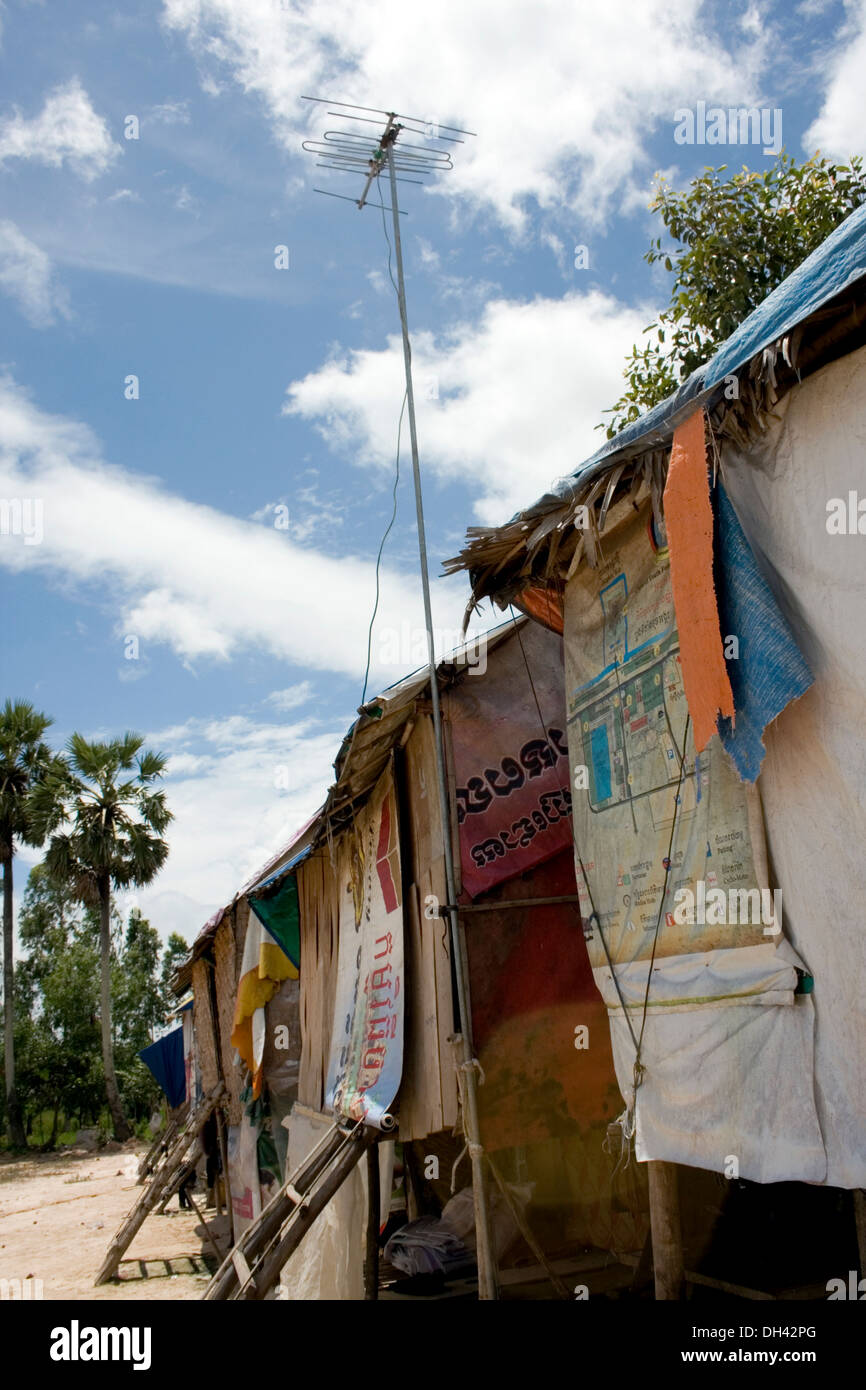 Une antenne est connectée à un plastique et bois maison dans un village près de charognards un dépotoir à Phnom Penh, Cambodge. Banque D'Images