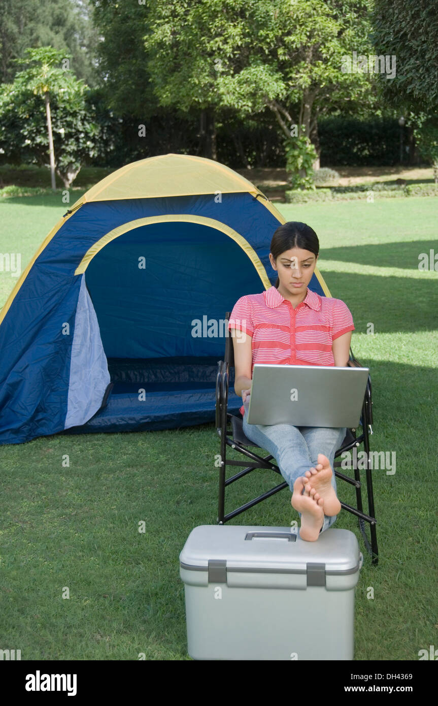 Woman using a laptop in a park Banque D'Images