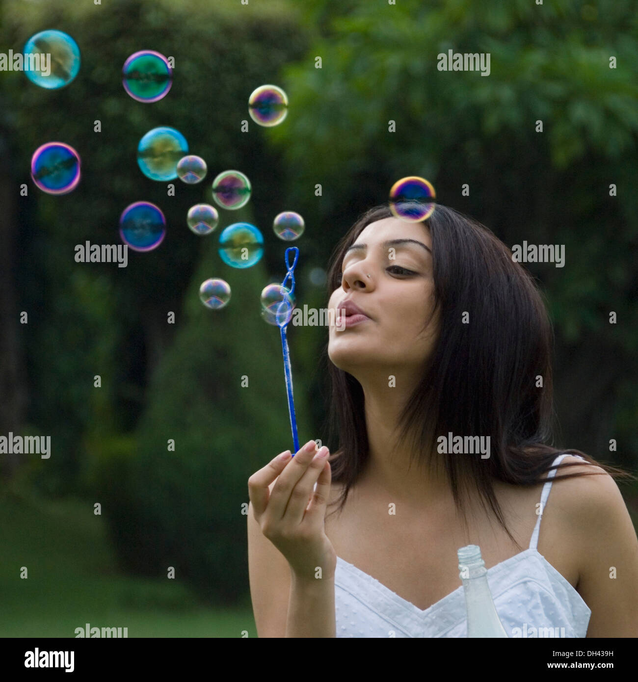 Femme soufflant des bulles de savon Banque D'Images