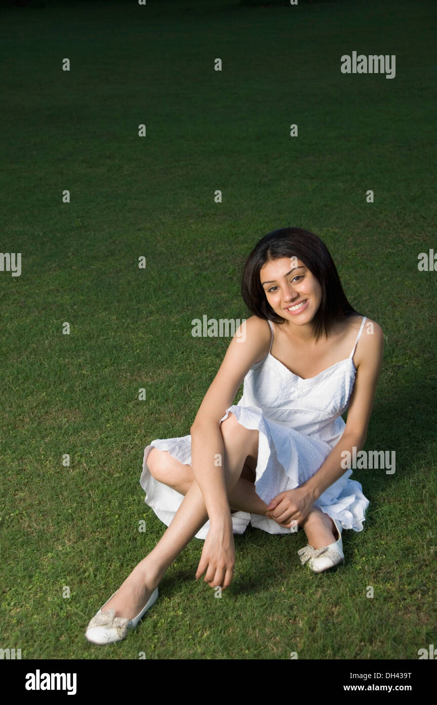 Femme assise dans un parc et souriant Banque D'Images