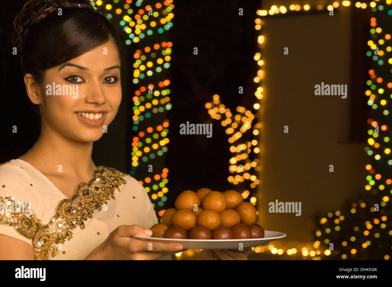 Woman holding bonbons dans une assiette et smiling Banque D'Images
