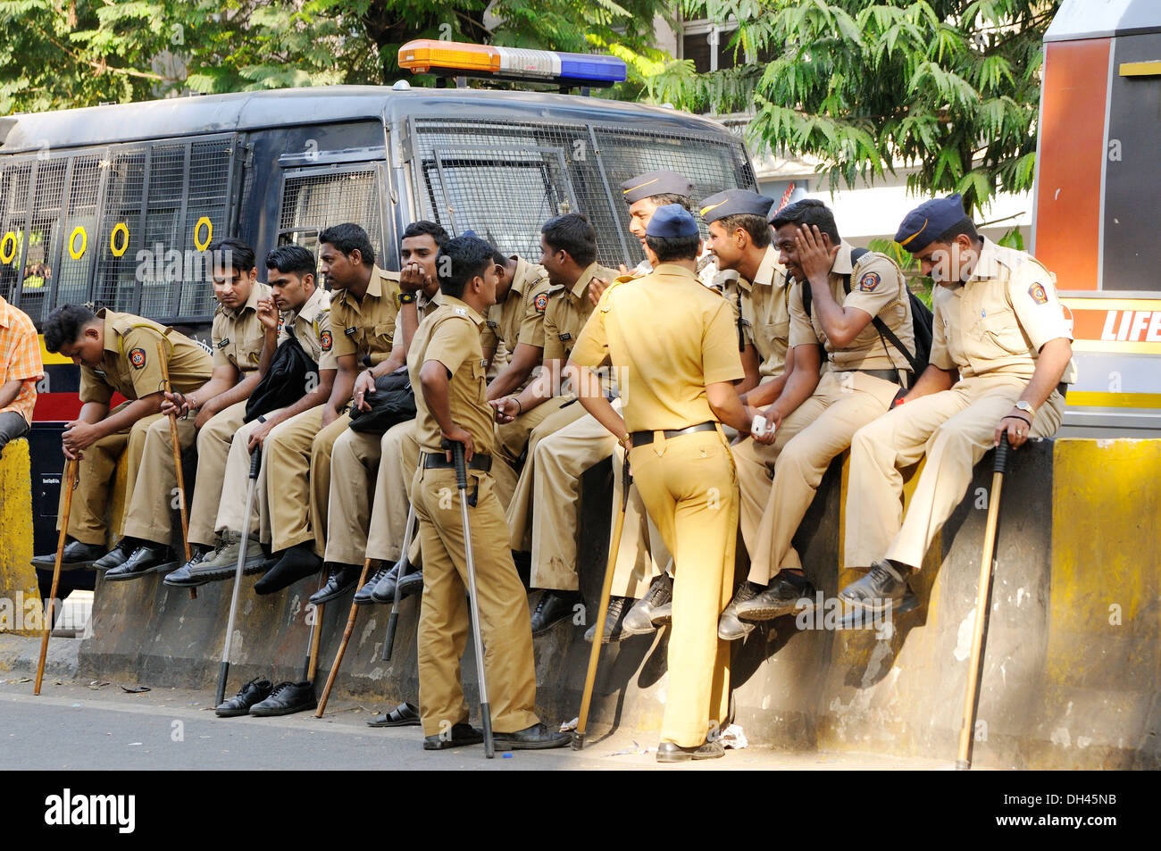 Policiers assis sur la route de séparation pour Balasaheb Thackeray procession funéraire Inde Maharashtra mumbai sécurité Novembre 2012 Banque D'Images