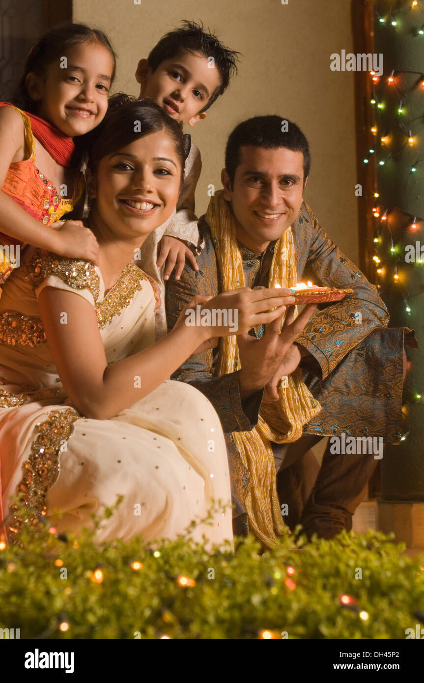 Couple holding offrande religieuse avec leurs enfants Banque D'Images