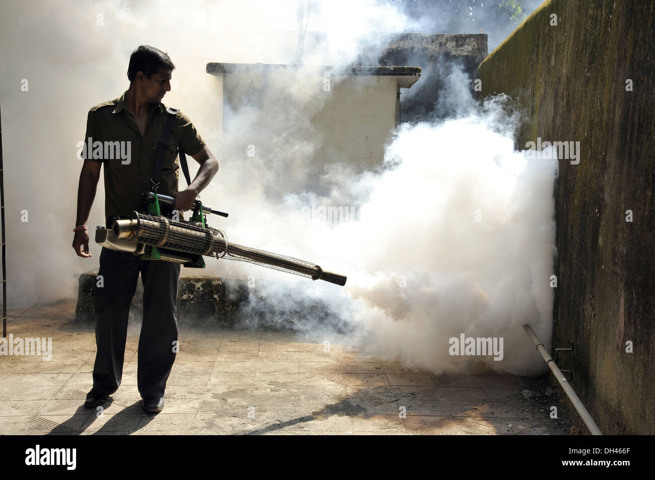 Brouillard , contrôle des insectes , homme pulvérisant des pesticides pour tuer les moustiques , Mumbai , Inde , asie Banque D'Images