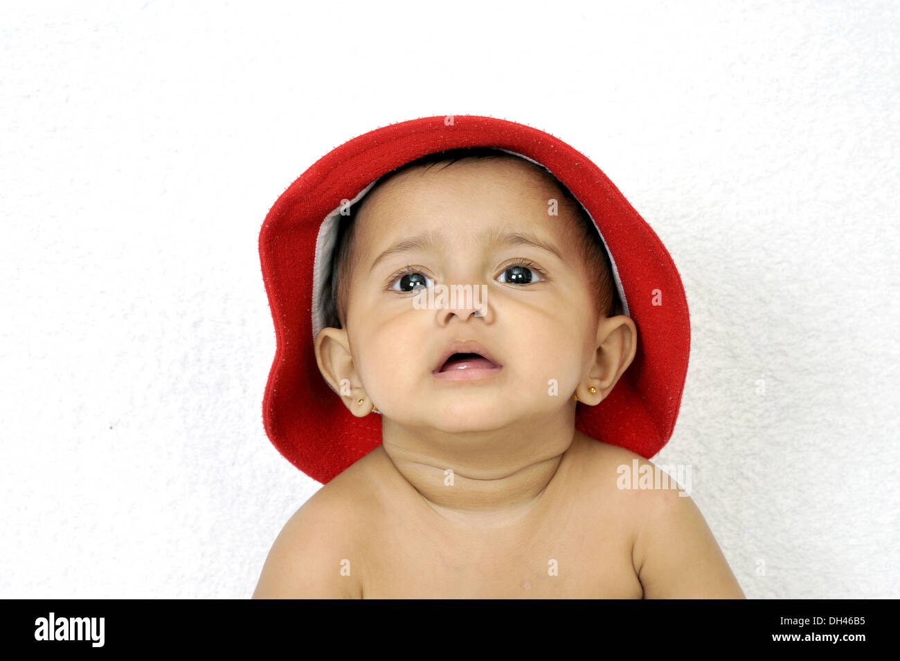 Bébé portant bonnet rouge fond blanc M.# 736LA Banque D'Images