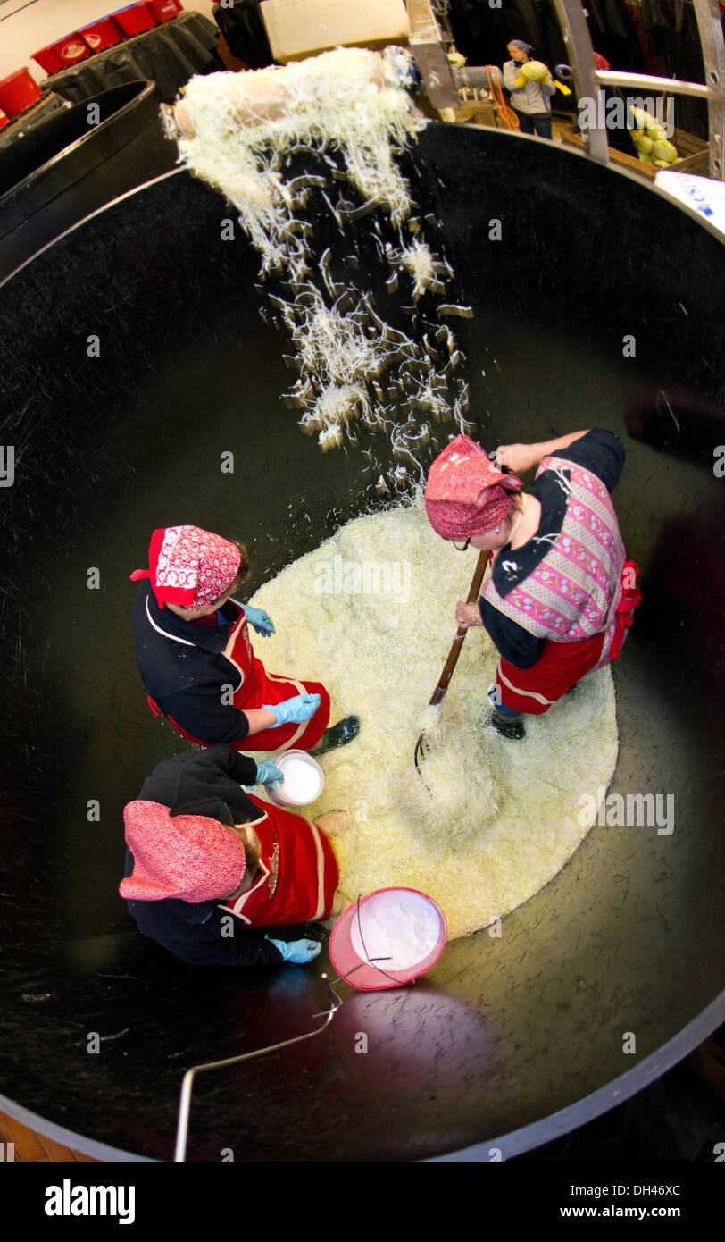Les employés de l'Spreewaldmueller & Co. société stand dans un grand récipient à couper le chou blanc tramp dans Luebbenau, Allemagne, 30 octobre 2013. La choucroute, la production a commencé dans le Spreewald. Couper finement le chou est versé dans d'énormes récipients et le sel et le cumin extrait sont ajoutés. Après six à huit semaines, la choucroute peut être rempli. Le Chou qui a été fermenté par les bactéries lactiques différents a une longue durée de vie. La choucroute est considérée à l'échelle internationale comme l'un des plus célèbres plats nationale allemande. Photo : Patrick Pleul/ZB Banque D'Images