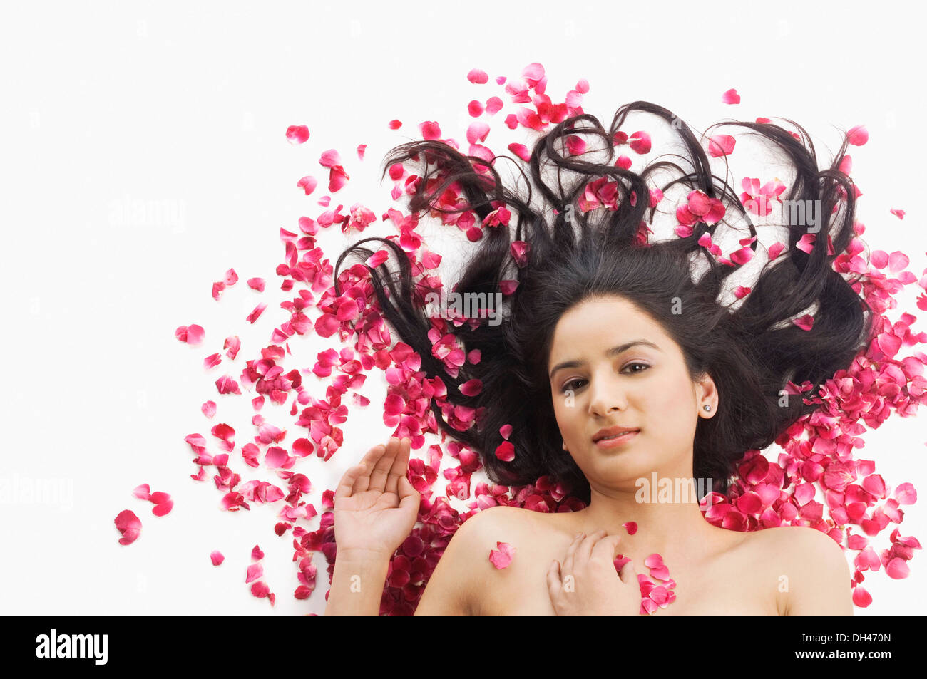 Femme couchée sur des pétales de rose Banque D'Images