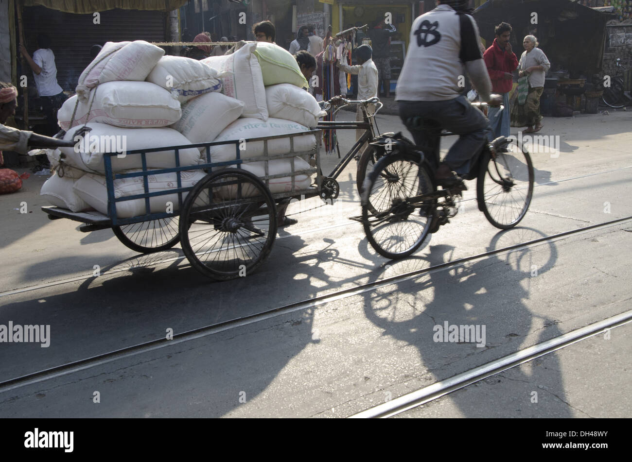 En poussant l'homme portent des sacs tricycle tirant kolkata West Bengal India Banque D'Images