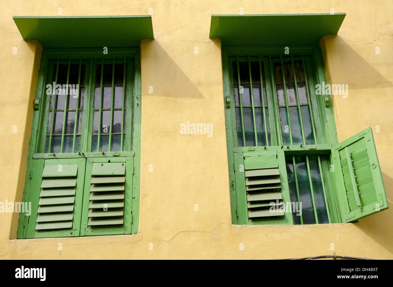 Fenêtres en bois peintes en vert mur peint en jaune de la maison Calcutta Kolkata Bengale occidental Inde Banque D'Images