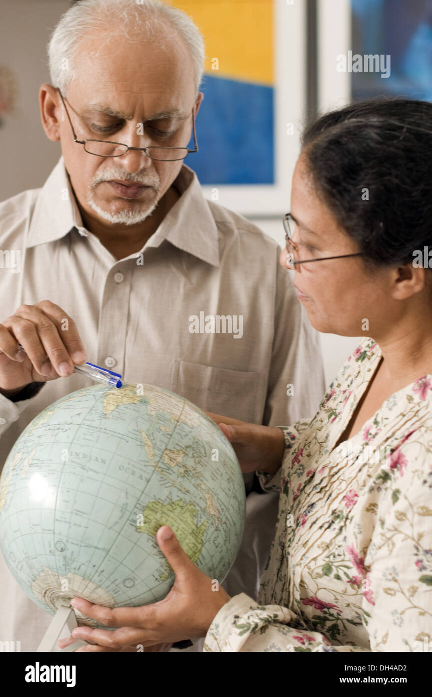 Man pointing lieu le monde globe pour femme Pune Maharashtra Inde Asie Avril 2012 M# 686P Banque D'Images