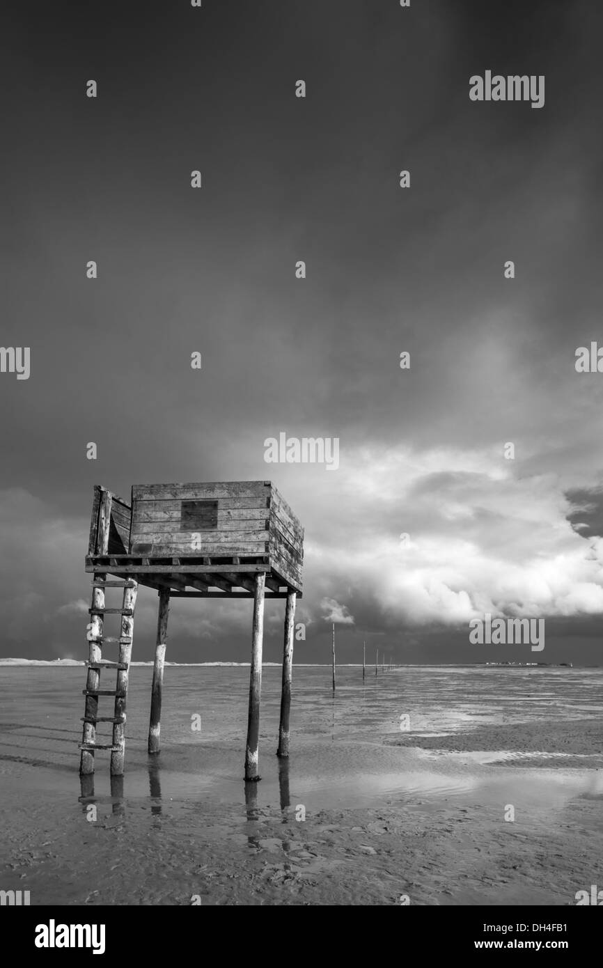 Refuge refuge et marqueurs pour le pôle ancien chemin du pèlerin sur Lindisfarne causeway en monochrome, Northumberland, England, UK Banque D'Images