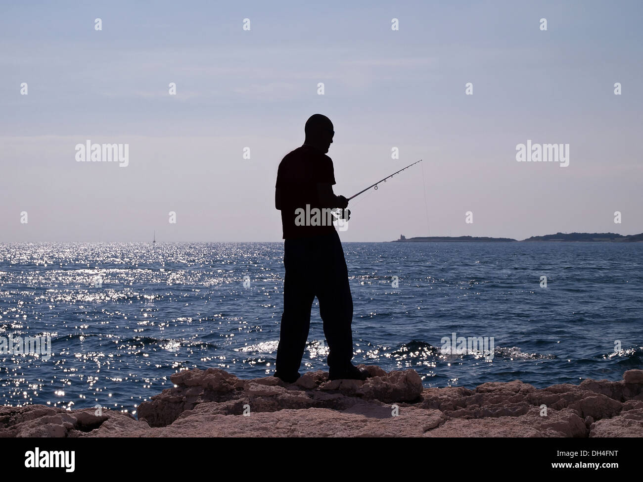 Pêche à l'homme dans la mer - silhouette d'un pêcheur Banque D'Images
