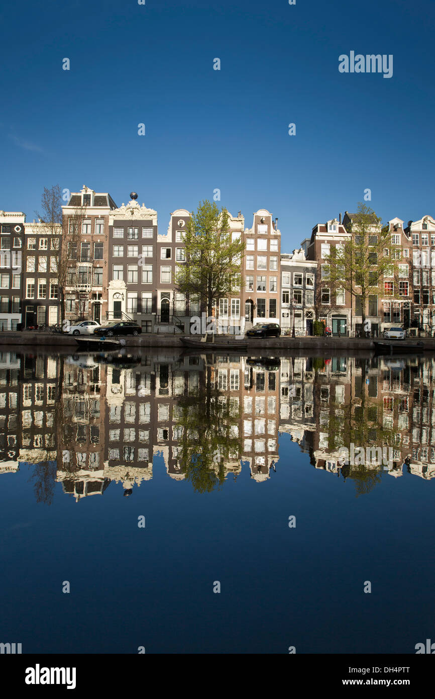 Les Pays-Bas, Amsterdam, reflet de maisons au bord du canal et péniches à canal appelé Singel. Unesco World Heritage Site. Banque D'Images