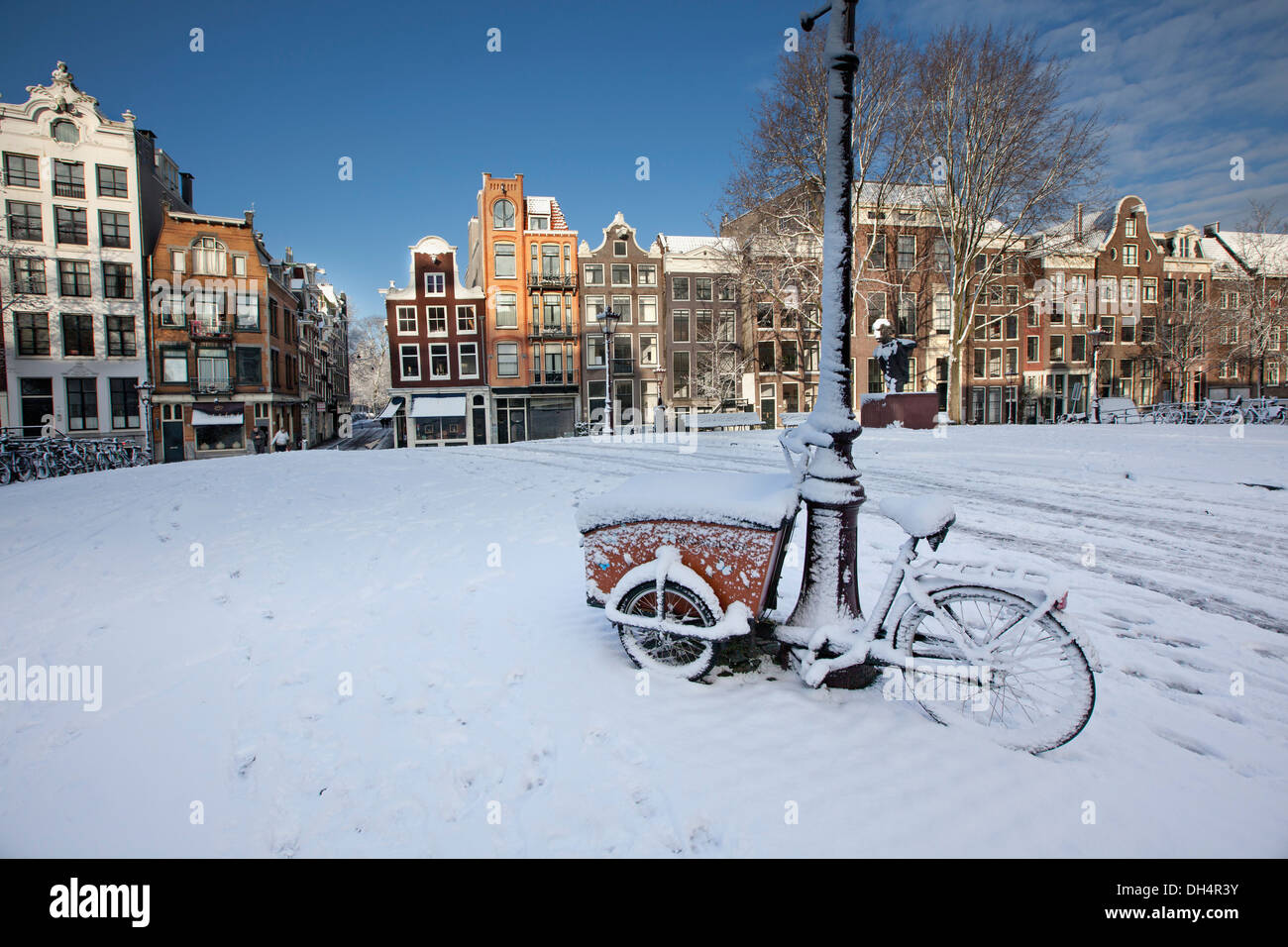 Les Pays-Bas, Amsterdam, Canal de maisons dans canal appelé Singel. Unesco World Heritage site. Tricycle ou vélo de cargaison. Snow Banque D'Images