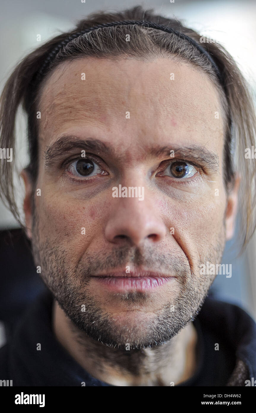 Un homme aux cheveux long fixe intensément dans l'appareil. Banque D'Images