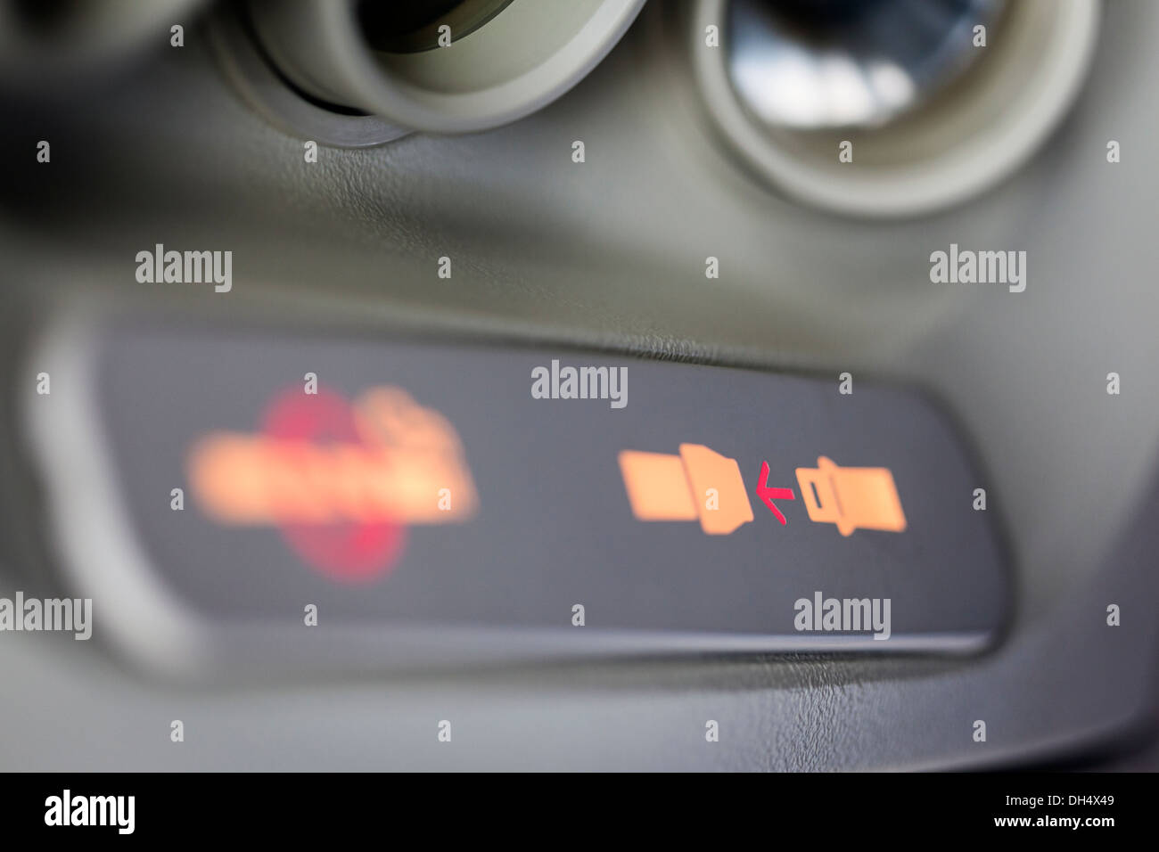 Close-up de l'allumé fixer signal de ceinture à l'intérieur d'un avion, selective focus sur la flèche rouge. Banque D'Images
