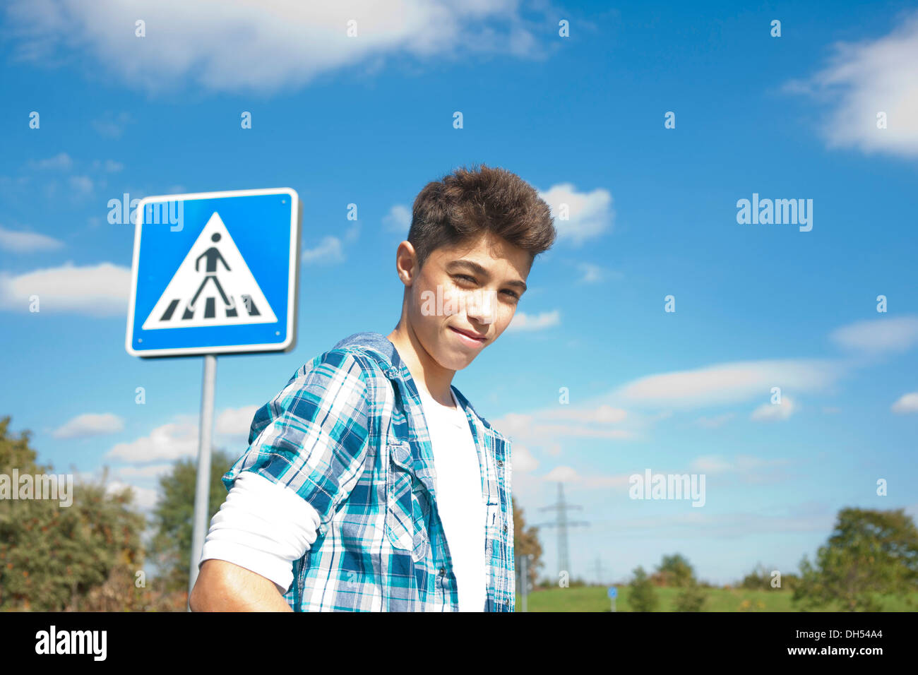 Boy, portrait en face d'une signalisation routière Banque D'Images