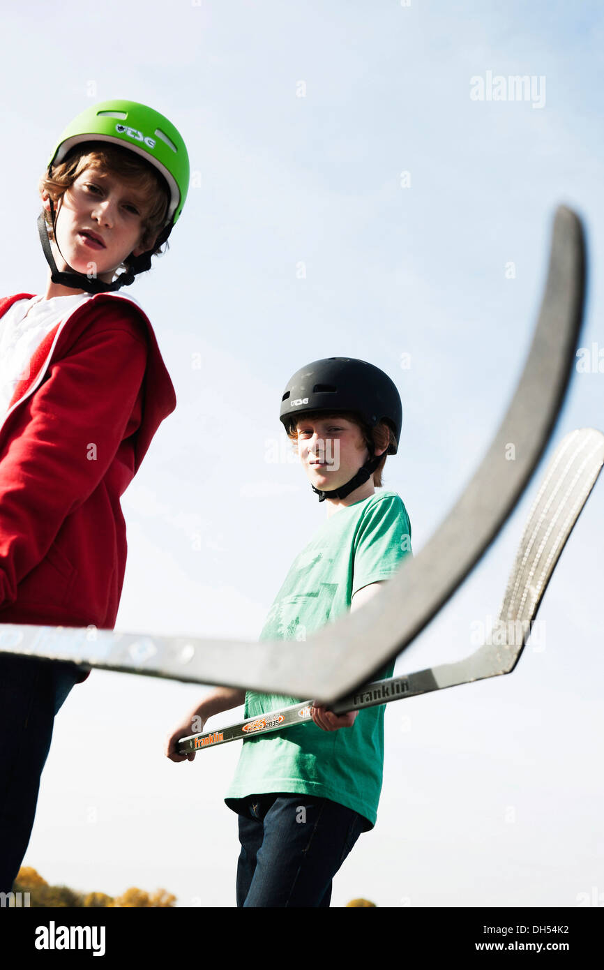 Deux garçons cool de jouer avec des bâtons de hockey roller hockey Banque D'Images