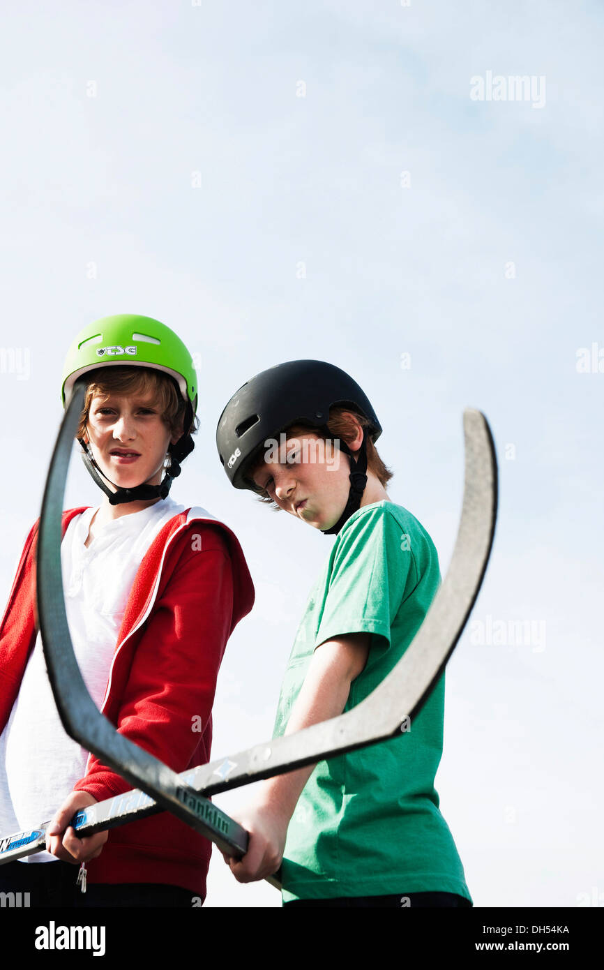 Deux garçons cool de jouer avec des bâtons de hockey roller hockey Banque D'Images