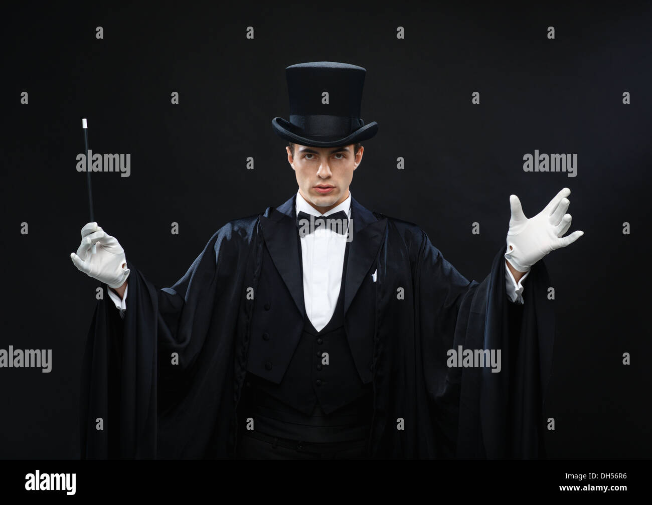 Magicien dans top hat avec Magic wand montrant trick Banque D'Images