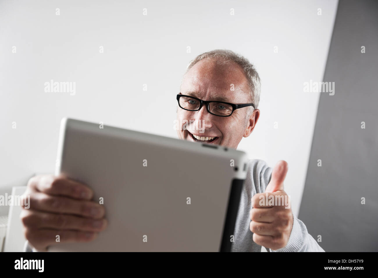 L'homme à l'aide d'un tablet PC, faisant un geste vers le pouce, Mannheim, Bade-Wurtemberg, Allemagne Banque D'Images