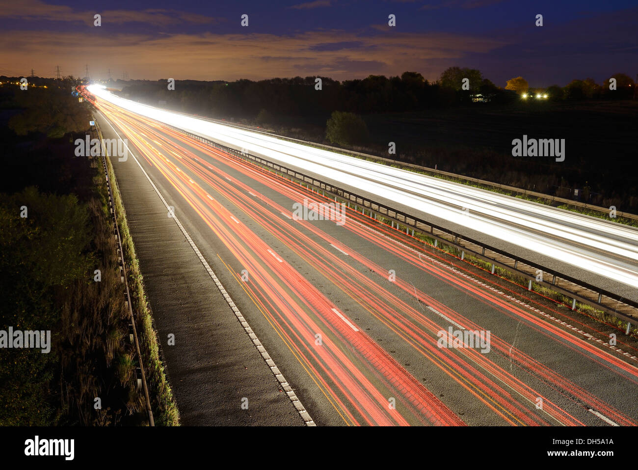 Exposition longue de soirée le trafic sur l'autoroute M56 UK Banque D'Images